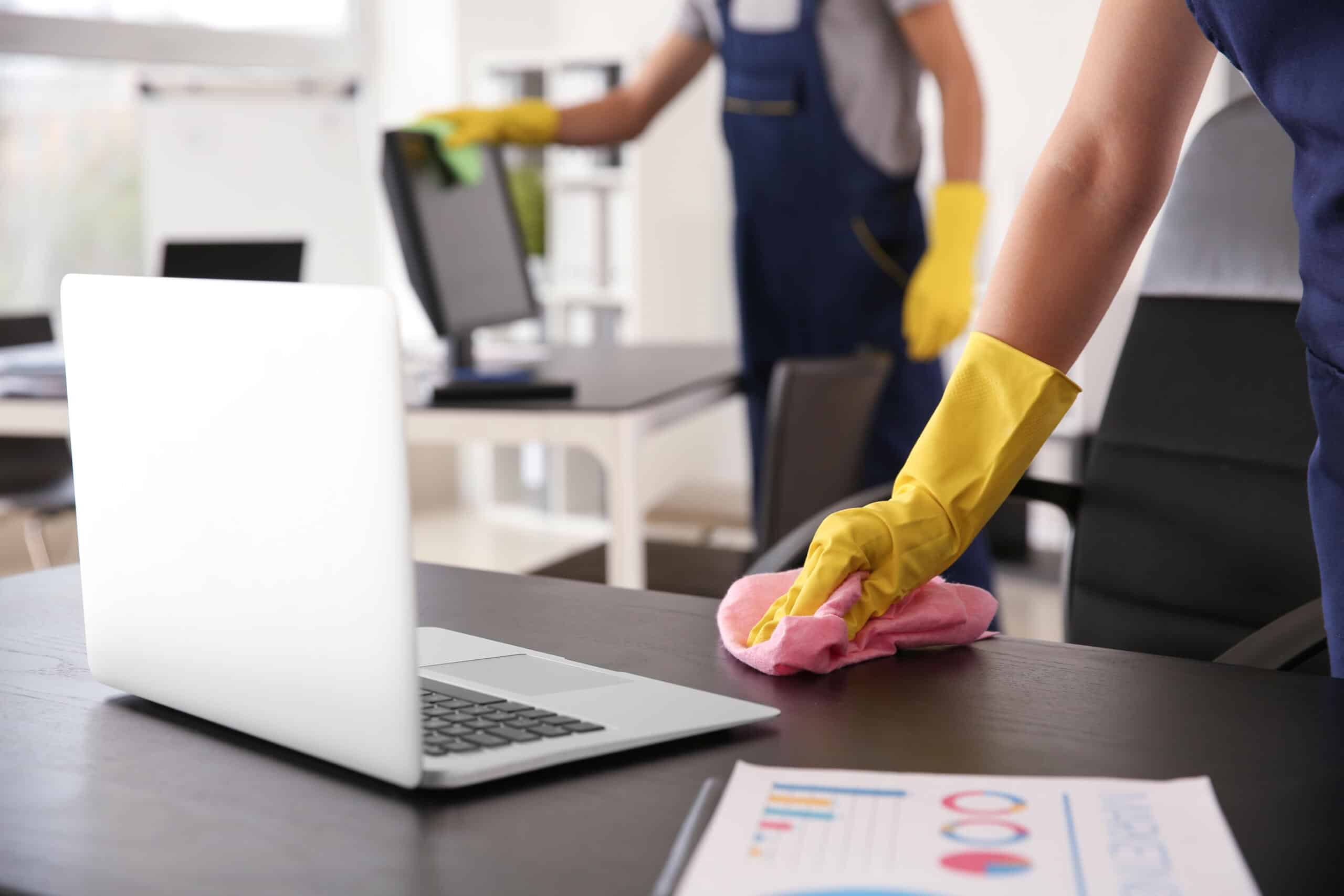 Cleaner wiping the desks in an office