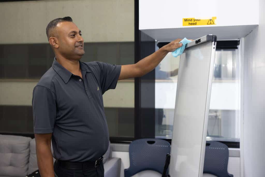 Jani-King cleaner wiping whiteboard