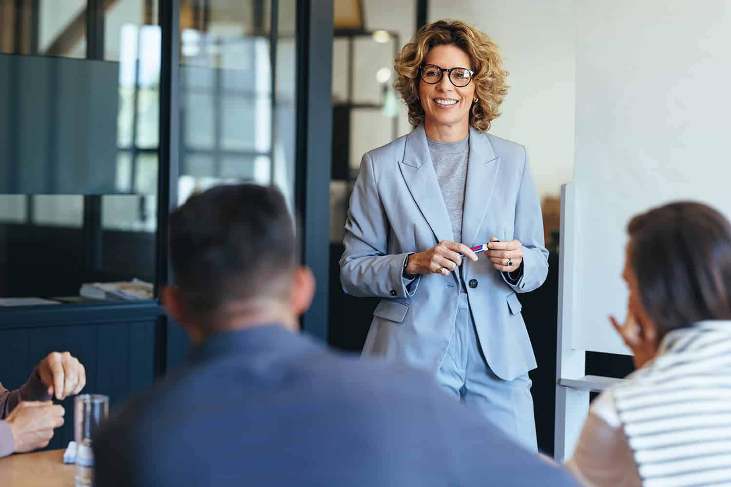 Mature business woman having a discussion with her team.