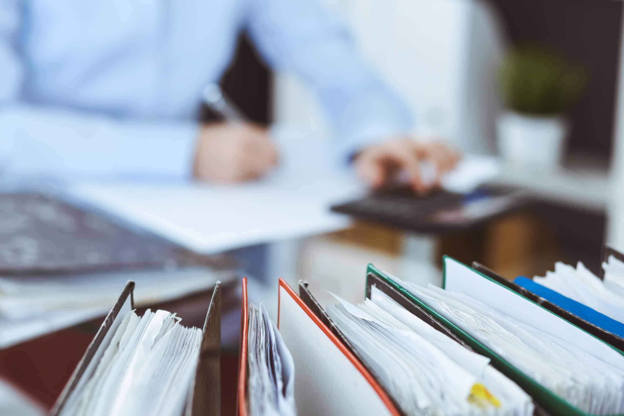 Business owners signing paperwork in front of files