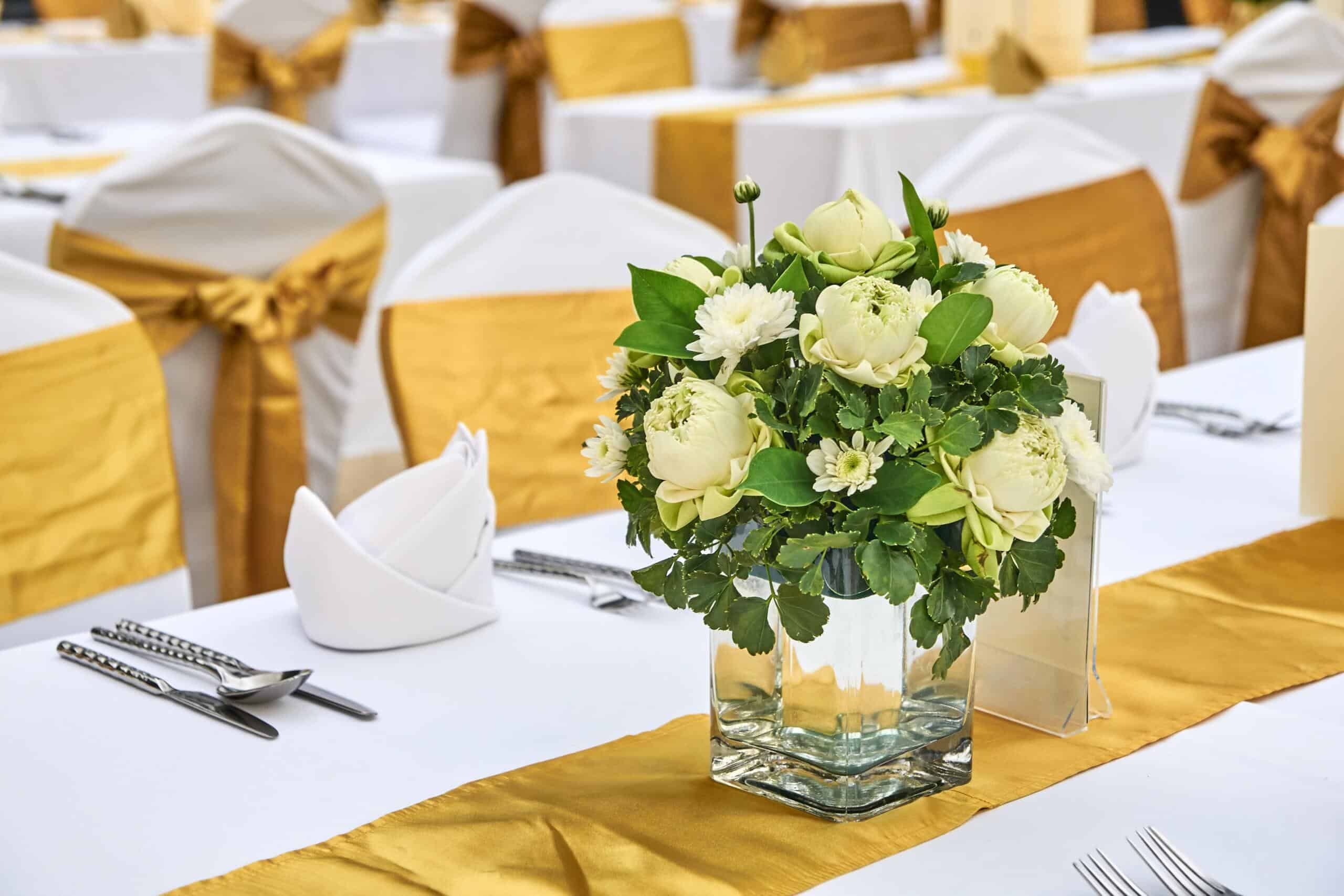 flower centrepiece on function table with gold table runners