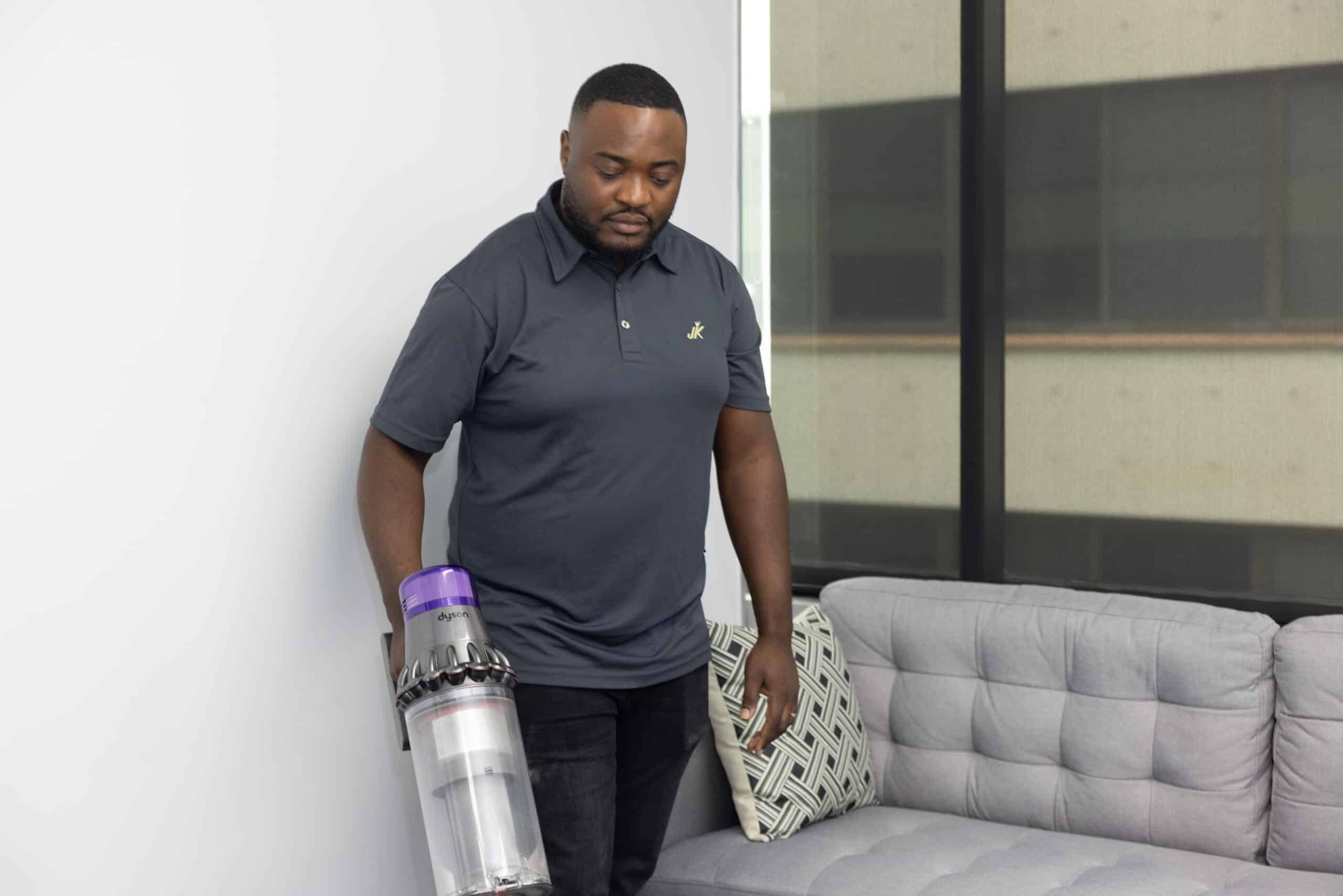 cleaner vacuuming next to couch
