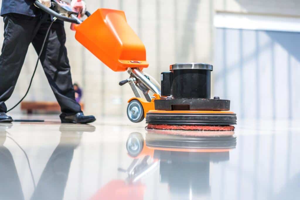 man in black pants and black shoes cleaning the floor