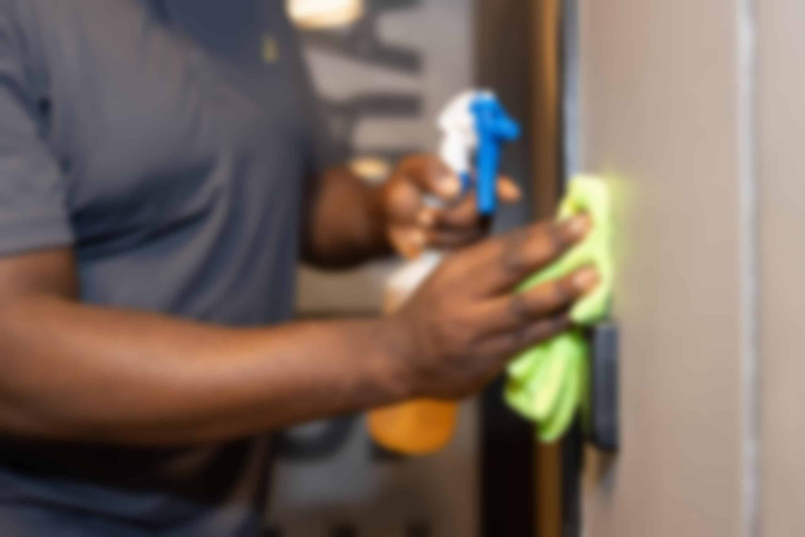 A close-up yet blurry image of man doing a cleaning services.